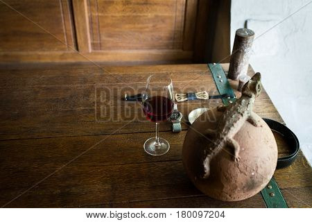 A glass of red wine on the wooden table. Men's accessorizes