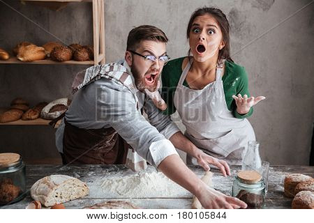 Shocked man and suprised woman trying to catch something on table with products