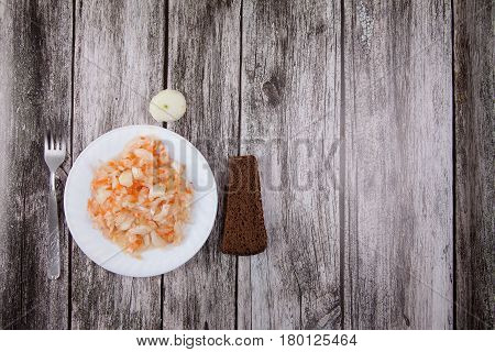 Sour Cabbage On A Plate And Black Bread On A Wooden Background