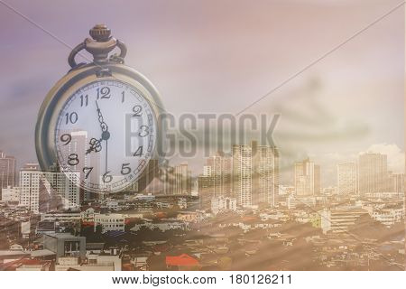 pocket watch over town center with double exposure effect time is make money in town business finance and competition concept