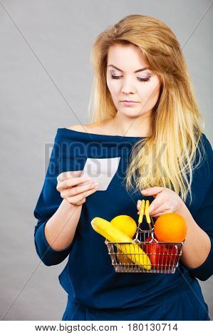 Worried Woman Holding Shopping Basket With Fruits