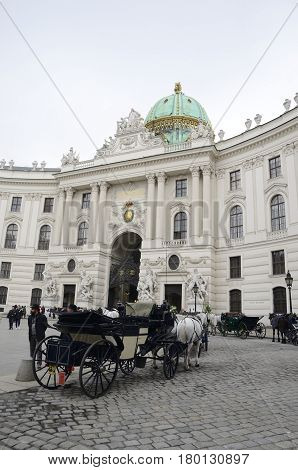 VIENNA, AUSTRIA - MARCH 21, 2017: Horse car in front of Hofburg Palace at Michaelerplatz in Vienna Austria.