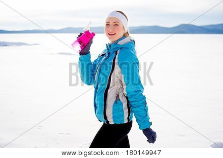 Sporty girl drinking water after workout. Healthy diet concept