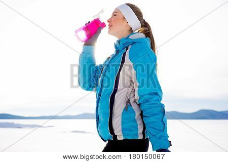 Sporty girl drinking water after workout. Healthy diet concept