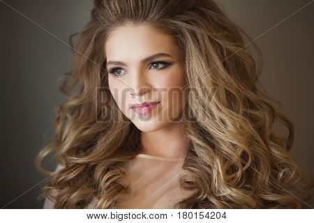 Portrait of a beautiful young painted girl with a smile on her face, with a lush hairdo