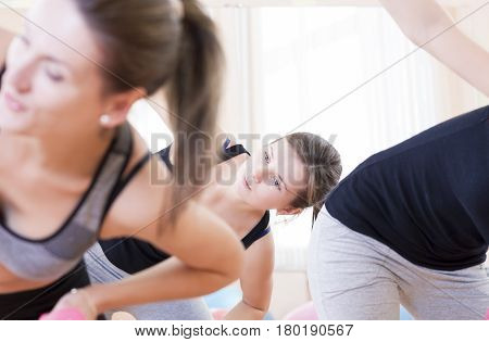Sport Concept and Ideas. Three Sportive Caucasian Active Women Doing Stretching Exercises with Barbells in Gym Class.Horizontal Image