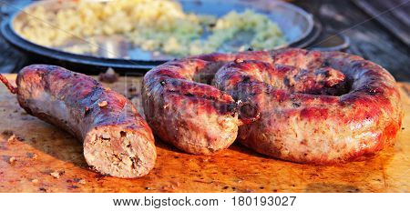 Delicious Sausages On Wooden Plate Cooked On Barbecue Grill