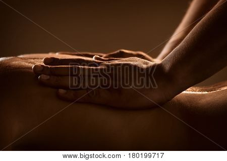 Massage closeup view with hands of professional masseur. Charming lighting