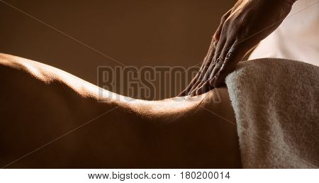 Massage closeup view with hands of professional masseur. Charming lighting