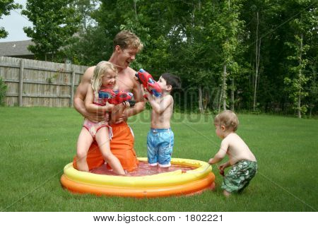Drenge og pige lege med far i barnlille Pool