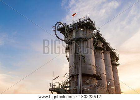 Silo on sunrise background, Storage plastic on sky background, Deliver resins to customers.