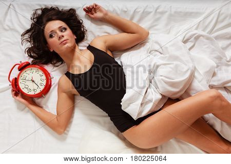 Sexy Lazy Girl Lying With Red Alarm Clock On Bed
