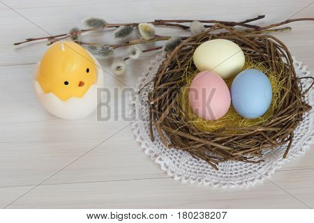 Bird's nest with Easter eggs and a candle.