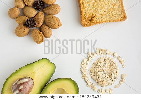 Sliced avocado oats toast and whole almonds view from above white background breakfast