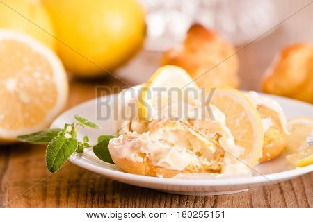 Profiteroles with lemon cream on white dish.