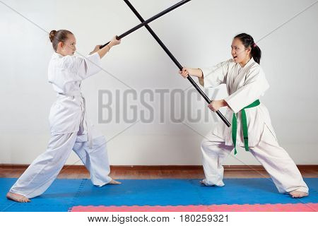 Two girls demonstrate martial arts working together. Fighting position active lifestyle practicing fighting techniques