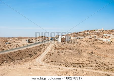 Highway in the desert passing through a small Arab town