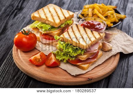 Club Sandwich With Tomato, Lettuce, Bacon, Ham And French Fries