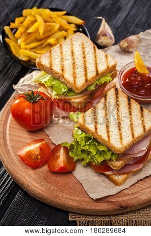 Club Sandwich With Tomato, Lettuce, Bacon, Ham And French Fries