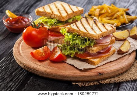 Club Sandwich With Tomato, Lettuce, Bacon, Ham And French Fries