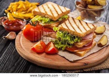 Club Sandwich With Tomato, Lettuce, Bacon, Ham And French Fries