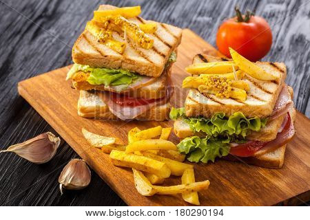 Club Sandwich With Tomato, Lettuce, Bacon, Ham And French Fries