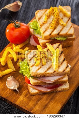 Club Sandwich With Tomato, Lettuce, Bacon, Ham And French Fries