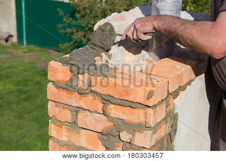 Builder mason building a chimney on the roof