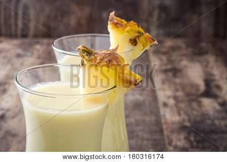Piña colada cocktail on wooden table background.