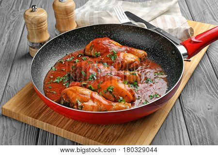 Frying pan with chicken cacciatore on kitchen table