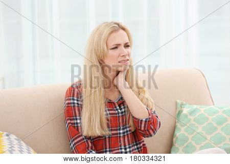 Young woman with allergy sitting on sofa at home