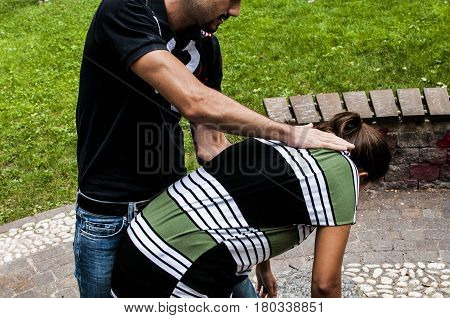 a guy helping a young girl with the heimlich desobstruction while she's choking
