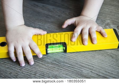 Spirit Level In Young Boy Hand - Child With Waterlevel