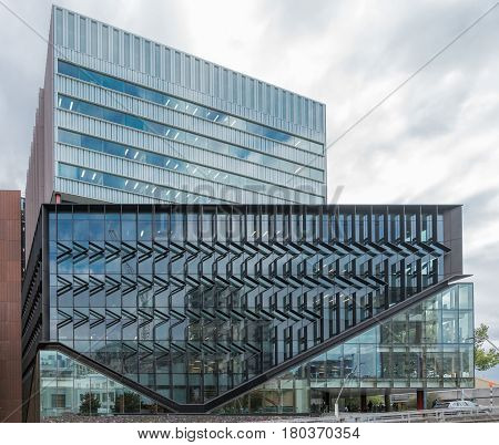 Auckland New Zealand - March 1 2017: Contemporary designed blue glass facade of science center of University of Auckland along Wellesley Street East. White gray skies.