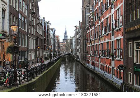 Amsterdam in April 2016. Netherlands. Canal, sluice, and bikes.