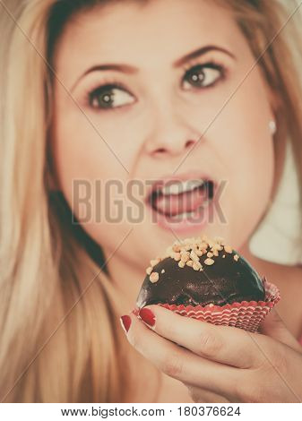 Woman Holding Chocolate Cupcake About To Bite