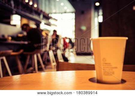 A cup of coffee - cafe blur background with warm tones