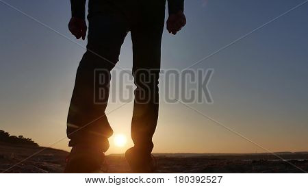 freedom. Man stands on cliff sunset silhouette hand in lifestyle the sides