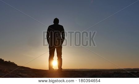 freedom. Man stands on cliff sunset silhouette hand lifestyle in the sides
