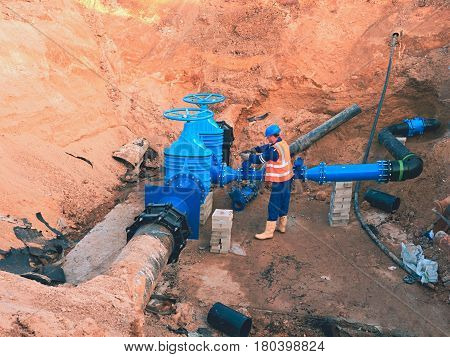 Main City Water Supply Pipeline. Technical Staff In Reflective Vest Underground