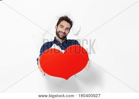 Loverman holding love heart in ripped studio