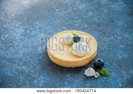 Individual Lemon Curd Tarts With Blueberry Jam Meringue Basil Leaves On A Blue Rusty Background. Fla