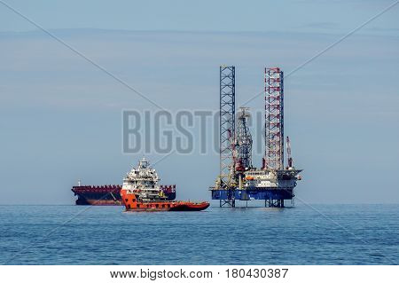 Labuan,Malaysia-Mac 25,2017:Multi function offshore support/platform supply vessels with the lay-up drilling jackup rigs in Labuan waters in the Brunei Bay area at Labuan island,Malaysia on 25th March 2017.