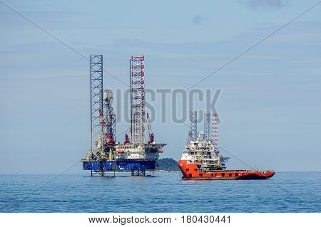 Labuan,Malaysia-Mac 25,2017:Multi function offshore support/platform supply vessels with the lay-up drilling jackup rigs in Labuan waters in the Brunei Bay area at Labuan island,Malaysia on 25th March 2017.