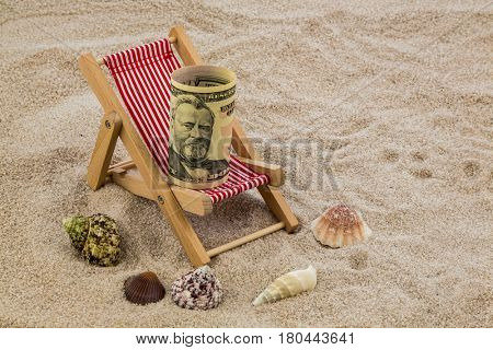 deckchair with piggy bank and dollars