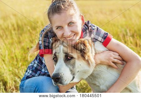 happy girl with her dog Central Asian Shepherd in rural areas in summer