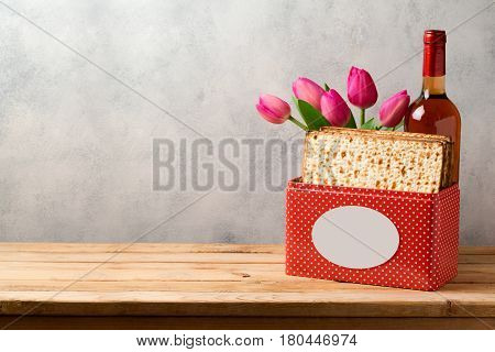 Passover celebration concept with matzoh wine and tulip flowers over bright background with copy space