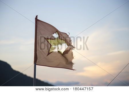 Tore Vietnam flag in sunset scene background