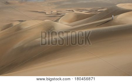young man walking in sand dunes in Liwa desert in Abu Dhabi