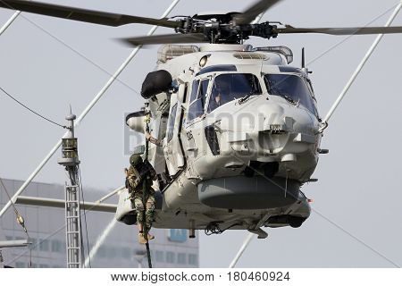 ROTTERDAM NETHERLANDS - SEP 3 2016: Anti-piracy demonstration with Dutch marines entering a vessel from a NH90 helicopter during the World Harbor Days in Rotterdam.